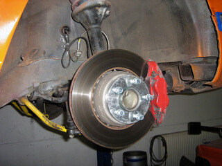 Repair of brake pads on a car. Wheel removed for brake replacement or repair