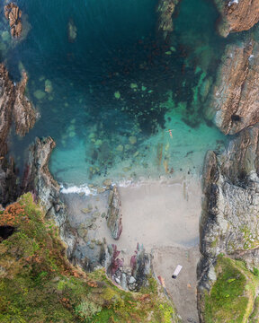 Aerial view of swimmer at secret cove, Talland Bay, Cornwall, United Kingdom.
