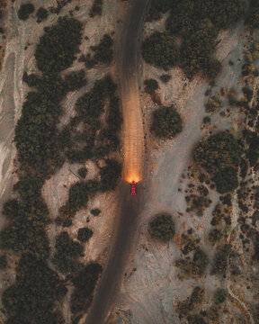 Aerial topdown shot of a red car in the Tabernas Desert, Andalusia, Spain.