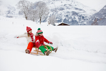 Fototapeta na wymiar Kids play in snow. Winter sleigh ride for children