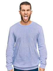 Young caucasian man wearing casual clothes sticking tongue out happy with funny expression. emotion concept.