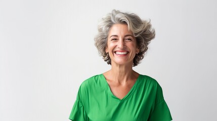 Portrait of happy mature woman in bright vivid green dress smiling to the camera isolated on white background with copy space.