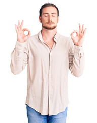 Young handsome caucasian man wearing casual clothes relax and smiling with eyes closed doing meditation gesture with fingers. yoga concept.