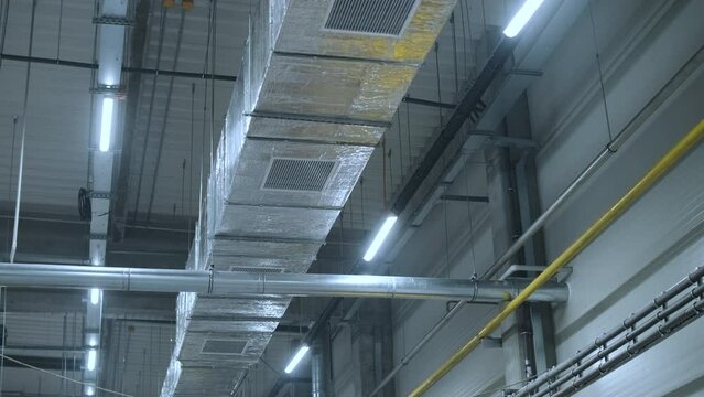 HVAC Duct Cleaning, Ventilation pipes in silver insulation material hanging from the ceiling inside new building.
