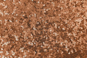 Vibrant shiny sparkly sequin textured holiday background peach color of the year 2024