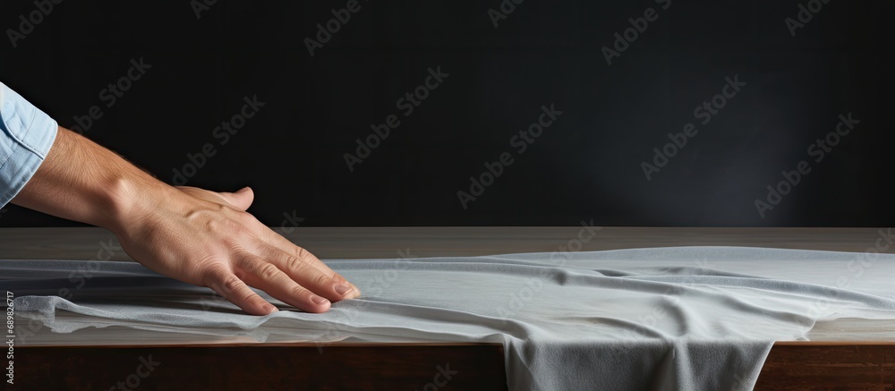 Poster cropped image of cleaner hands cleaning a white table with a blue cloth. copyspace image. square ban