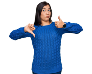 Young hispanic woman wearing casual clothes doing thumbs up and down, disagreement and agreement expression. crazy conflict