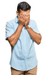 Fototapeta premium Handsome hispanic man wearing casual clothes with sad expression covering face with hands while crying. depression concept.