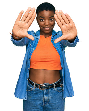 Young african american woman wearing casual clothes doing frame using hands palms and fingers, camera perspective