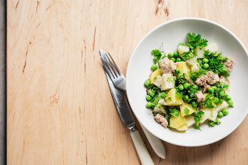 Potato salad with tuna and green peas.