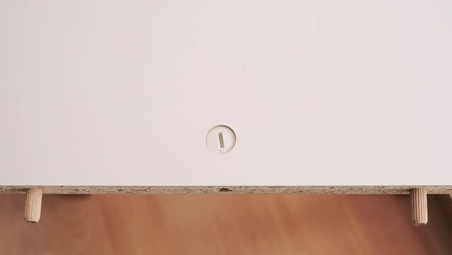The furniture assembler starting to assemble the interior furniture, open twists, screw and fixers, hands with a close-up