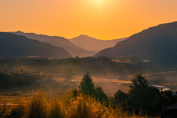 Fototapeta premium Golden light at sunset over the mountains in rural Lesotho