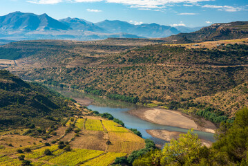 A river runs through a valley in rural Lesotho, with farms on the banks and mountains on the horizon © Jennifer