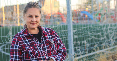 cute adult woman street portrait against the backdrop of the sports field grid