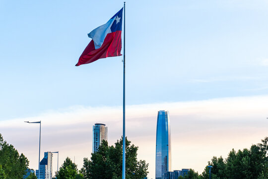 La bandera de Chile flameando con la ciudad De Santiago de fondo en el atardecer. Tomada en la comuna de Vitacura. 