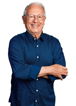 Senior man with grey hair wearing casual shirt and glasses happy face smiling with crossed arms looking at the camera. positive person.