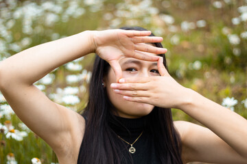 Joven hermosa mujer  casual sobre fondo naturaleza aislado cubriendo los ojos con las manos, sonrisa segura en la cara y emoción sorpresa.