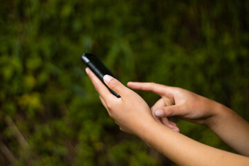 Empresaria usando tel&eacute;fono celular, de mano sosteniendo el tel&eacute;fono  con fondo de desenfoque, navegando por internet con dispositivo celular