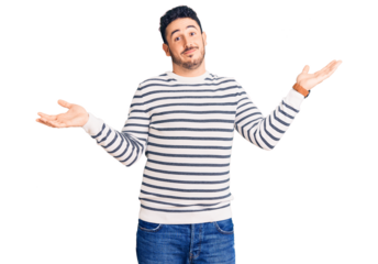 Young hispanic man wearing casual clothes clueless and confused expression with arms and hands raised. doubt concept.