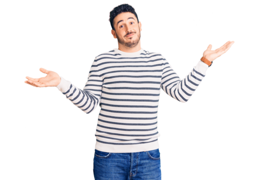 Young hispanic man wearing casual clothes clueless and confused expression with arms and hands raised. doubt concept.