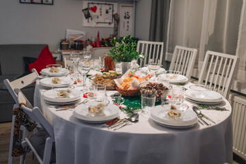 Polish Wigilia. Christmas Eve red borscht soup with mushroom filled ravioli and beet chips and sauerkraut with mushrooms on festive table. High quality photo