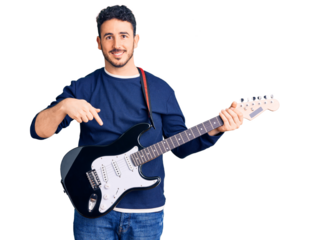 Young hispanic man playing electric guitar smiling happy pointing with hand and finger