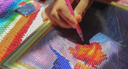 Diamond mosaic painting fragment of making close-up top view, handmade hobby.