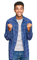 Young handsome african american man wearing casual clothes celebrating surprised and amazed for success with arms raised and open eyes. winner concept.