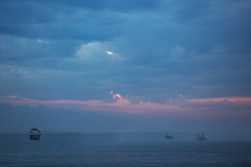 Fishing boats in the ocean. Fog in the ocean at dawn. Copy space.