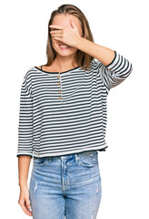 Fototapeta premium Beautiful blonde woman wearing casual clothes smiling and laughing with hand on face covering eyes for surprise. blind concept.