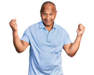 Hispanic middle age man wearing casual t shirt screaming proud, celebrating victory and success very excited with raised arms