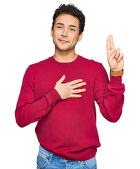 Young handsome man wearing casual clothes smiling swearing with hand on chest and fingers up, making a loyalty promise oath