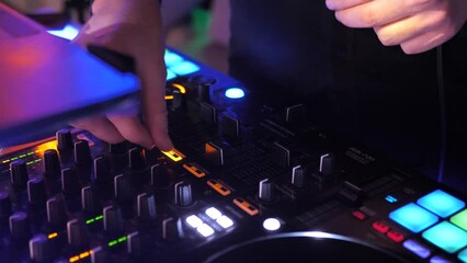DJ hands touching buttons and sliders while playing electronic music.DJ console