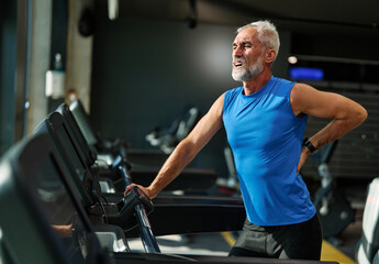 gym sport fitness exercising training mature man running cardio treadmill tired exhausted resting...