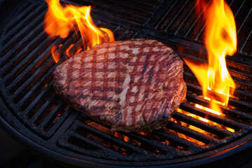 Traditional American barbecue flanksteak steak as close-up on a charcoal grill with fire