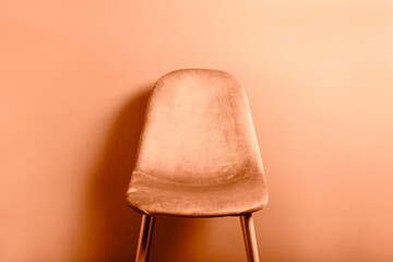 Modern Velour Chair Peach Fuzz, color of the year 2024 on wooden legs, grey background