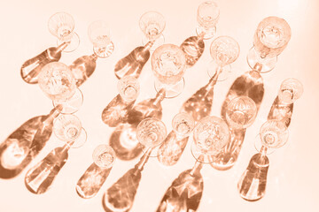 Variety of empty glasses on peach background with trendy hard shadows and sun light. Shadow overlay...