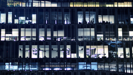 Fragment of the glass facade of a modern corporate building at night. Modern glass office  in city. 