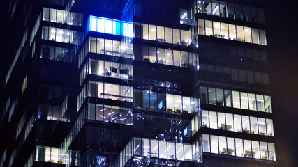 Fragment of the glass facade of a modern corporate building at night. Modern glass office  in city....