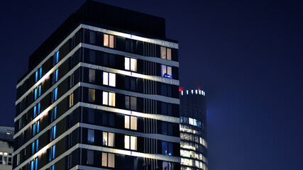Glowing windows of the multi-storey building in night. View of modern residential building in...
