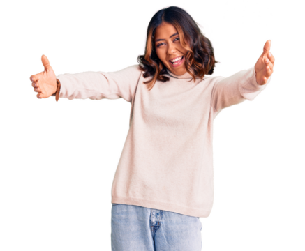 Young beautiful mixed race woman wearing winter turtleneck sweater looking at the camera smiling with open arms for hug. cheerful expression embracing happiness.