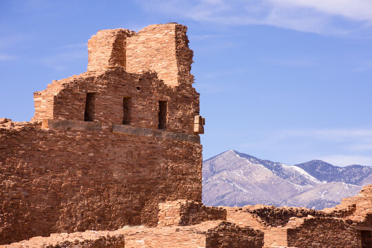Abo Mission Ruins, New Mexico, with purple Manzano Mountains in the distance and blue sky. Full sun. 