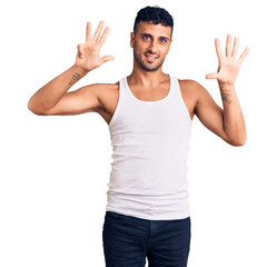 Young hispanic man wearing casual clothes showing and pointing up with fingers number nine while...