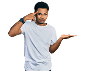 Young african american man wearing casual white t shirt confused and annoyed with open palm showing copy space and pointing finger to forehead. think about it.