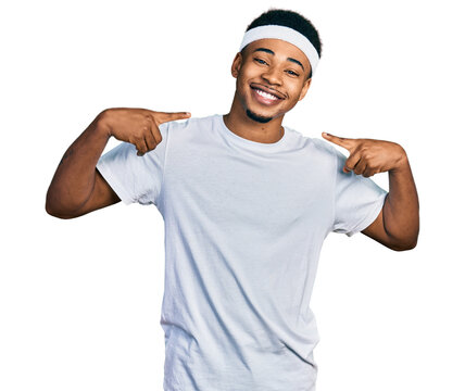 Young african american man wearing sportswear looking confident with smile on face, pointing oneself with fingers proud and happy.