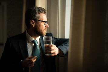 Tired man feel pain holding glasses rubbing dry irritated eyes fatigued from computer work. Man taking a Medicine pill from headache migraine.