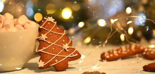 Cup of hot chocolate and Christmas gingerbread cookie on table, closeup. Banner for design