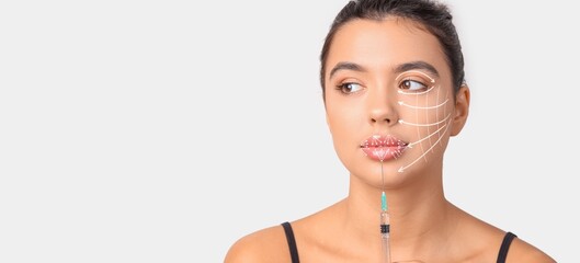 Young woman holding syringe on light background with space for text. Skin care concept