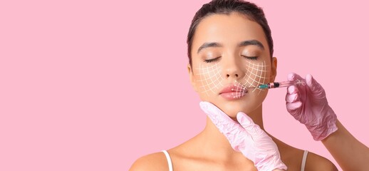 Young woman receiving filler injection in face against pink background with space for text. Skin care concept