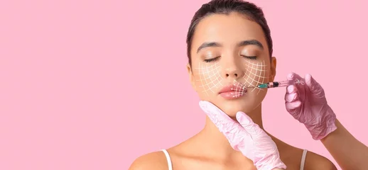 Foto op Canvas Young woman receiving filler injection in face against pink background with space for text. Skin care concept © Pixel-Shot
